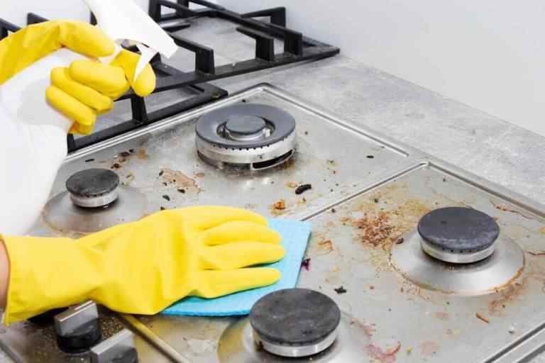 Professional cleaning services scrubbing heavy grease and residue off a Wapato kitchen stove