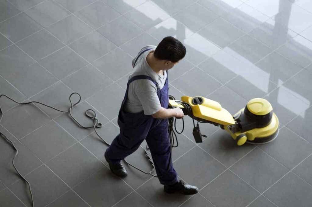 Professional cleaning services worker operating a heavy-duty floor buffer on tile in Zillah